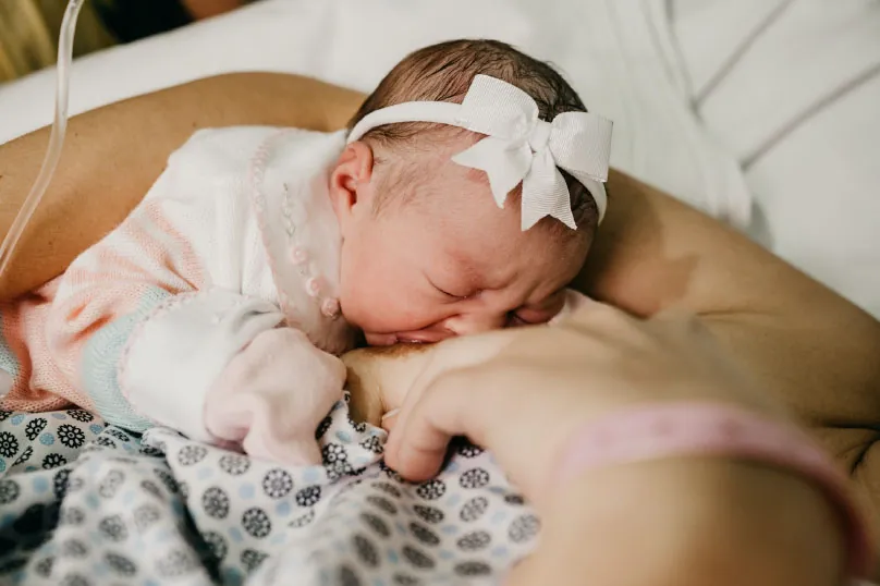Photo of infant breastfeeding.