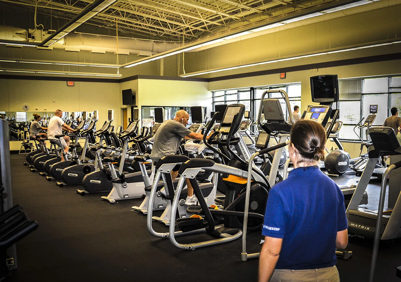 Several people exercise on stationary bike in a gym.