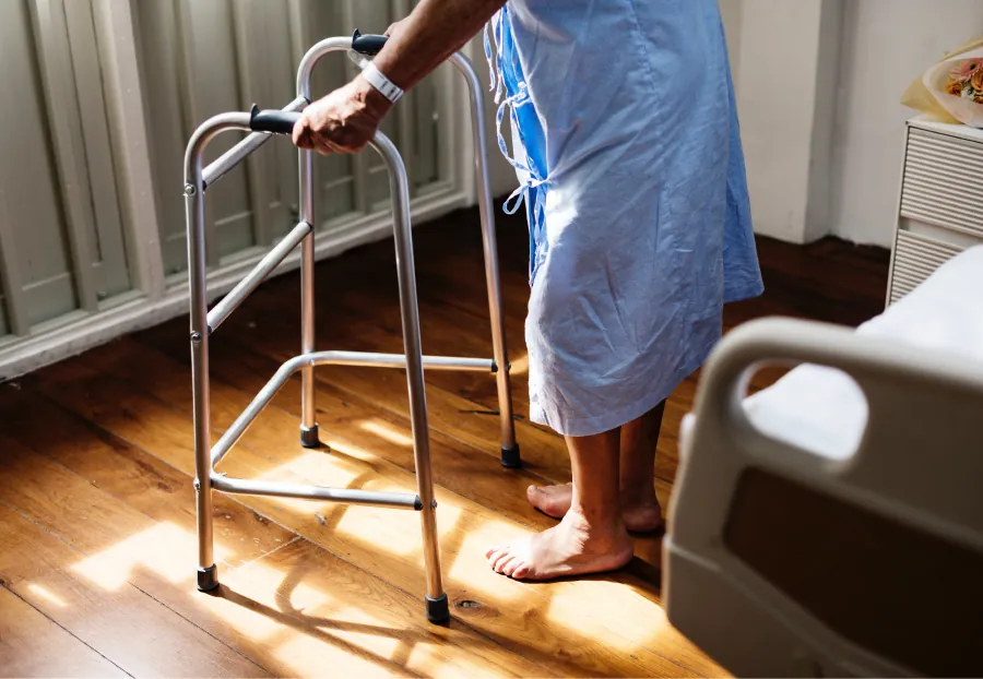 A patient uses a walker to stand.