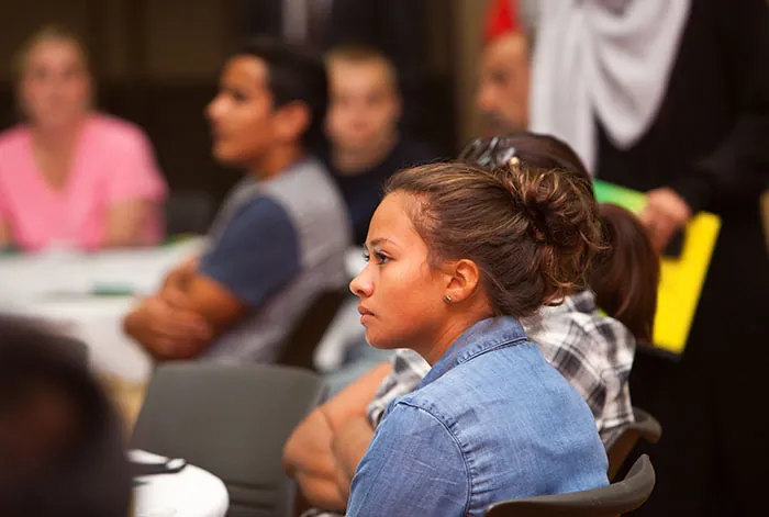  A student is sitting in a room full of other students.