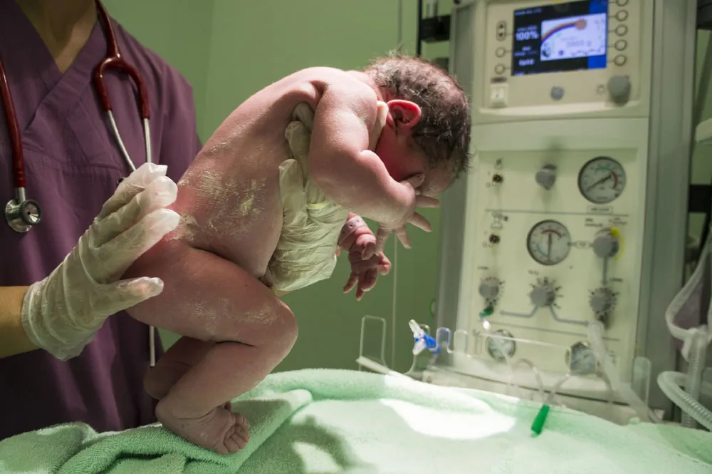 Nurse holding newborn.