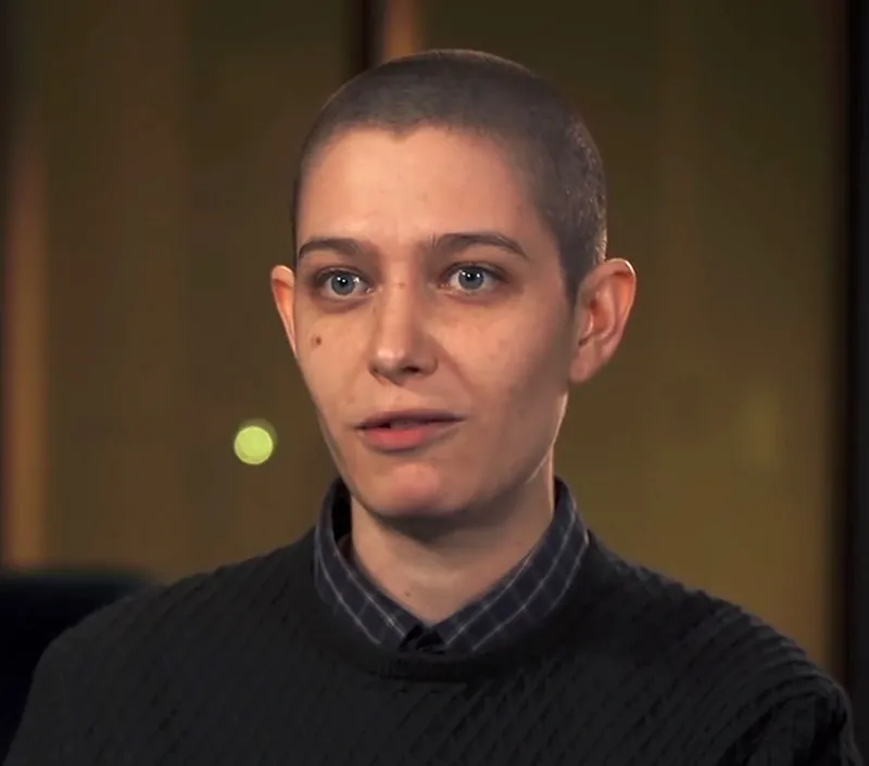 A photo shows a close-up portrait of Asia Kate Dillon.