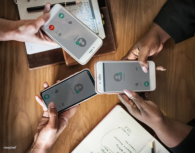 A close-up view of three people holding cell phones.