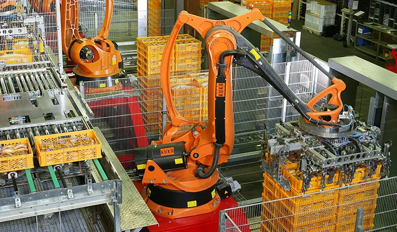 Zdjęcie przedstawia halę produkcyjną piekarni, która jest obsługiwana przez roboty.
