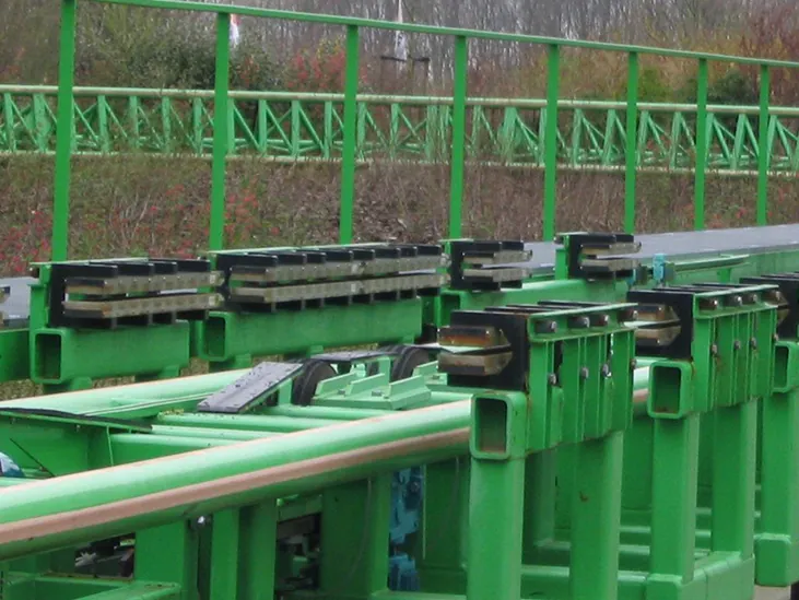Zdjęcie przedstawia rzędy magnesów systemu magnetycznego hamowania wagoników kolejki górskiej, spotykanej w wesołych miasteczkach. Magnesy, których bieguny tworzą poziome, wąskie szczeliny – umieszczone są po obu bokach toru kolejki w kształcie płytkiej rynny.