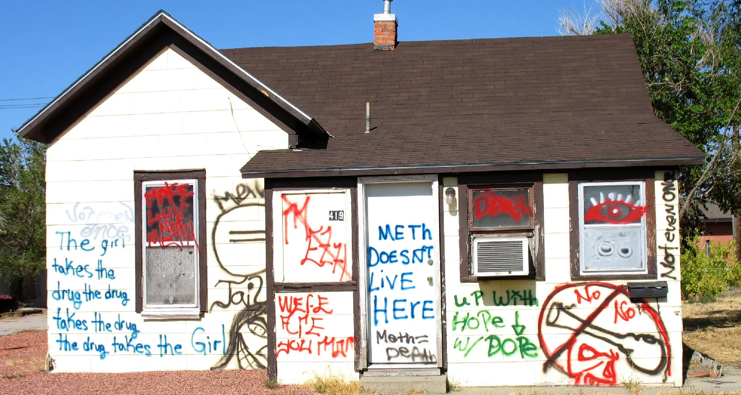 A small house is spray painted with anti-drug use graffiti.