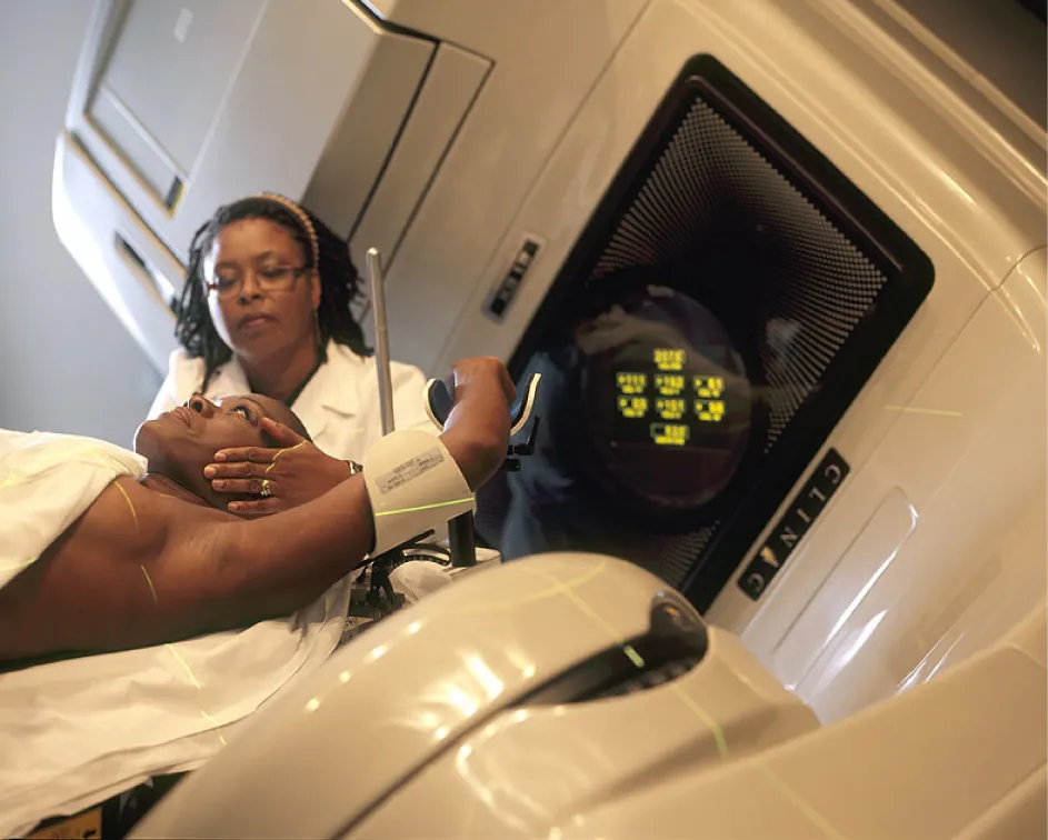 Healthcare provider administering radiation therapy to patient