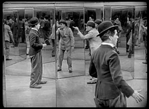 This black-and-white still shot shows Charlie Chaplin and a thief in a maze of mirrors. Images of Chaplin and the thief appear in mirrors, within mirrors, within mirrors.