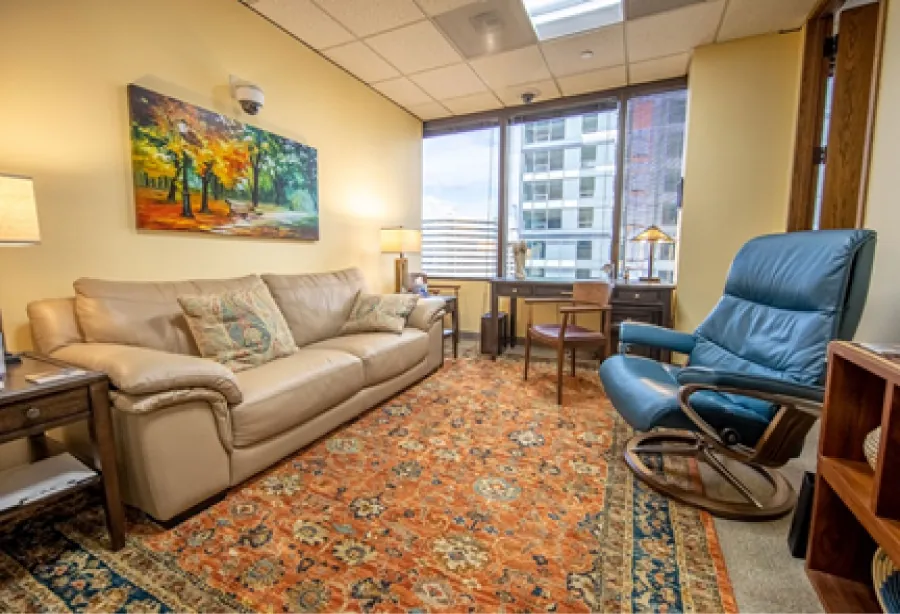 Photo of Gottman Institute “Love Lab” room with couch, chairs, and large windows.
