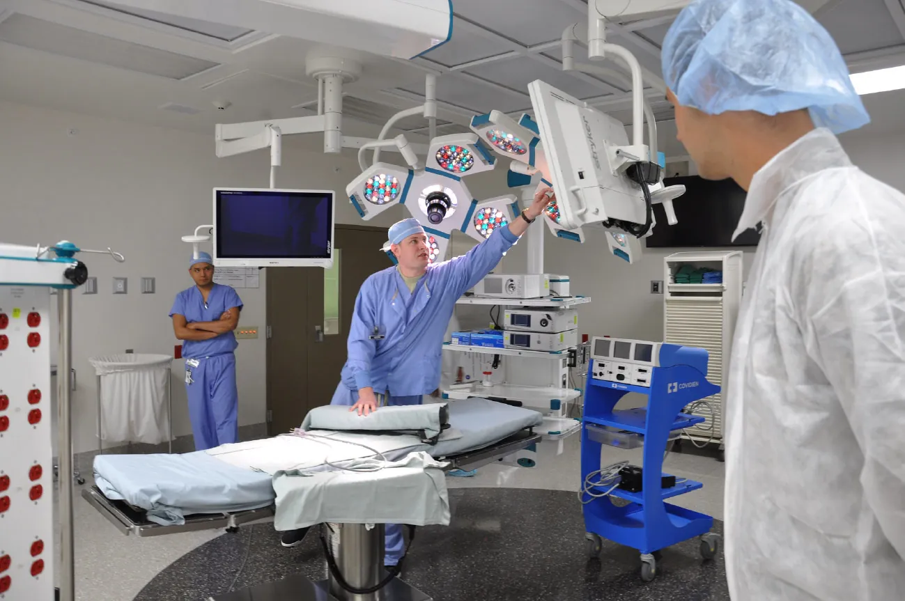 A photograph of three medical team members in a high-tech operating room.