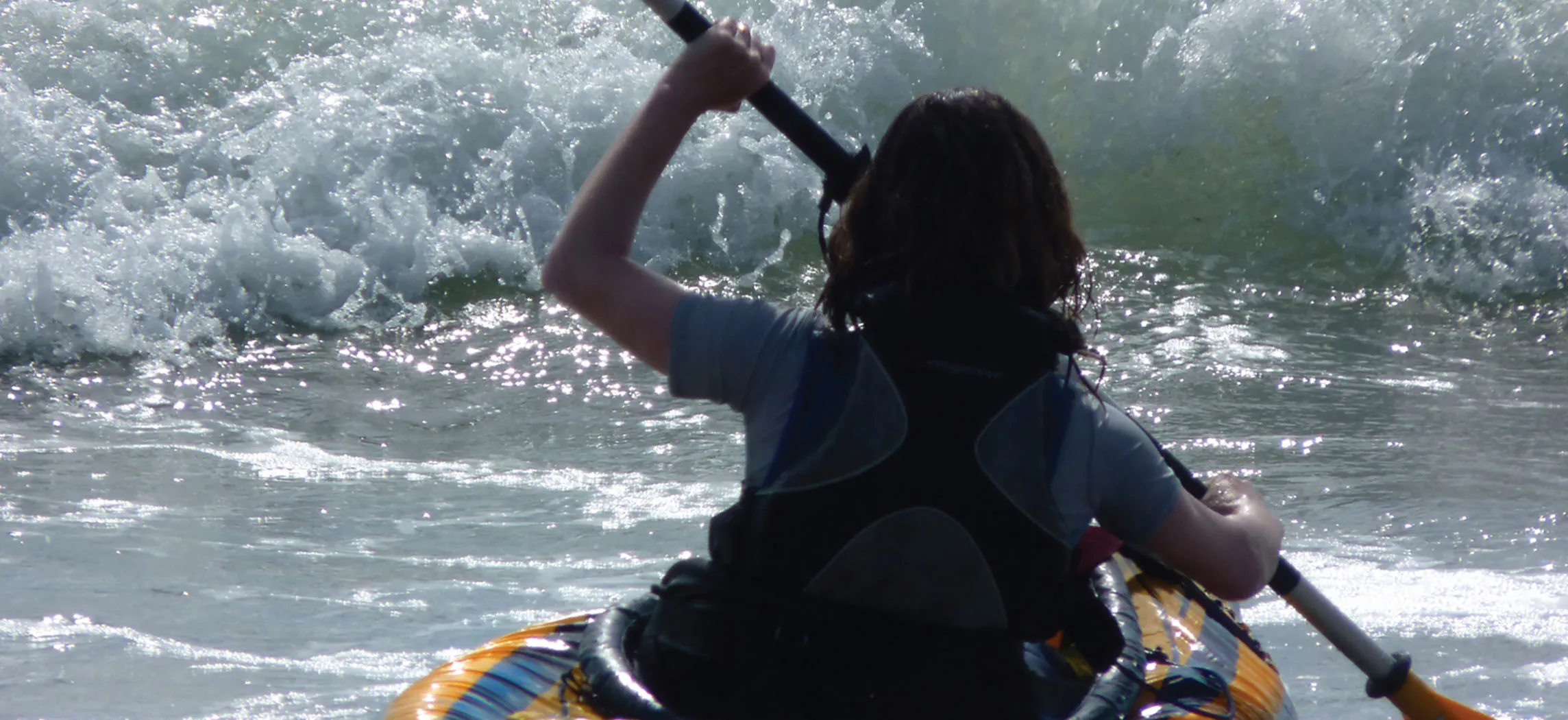 This picture shows a girl kayaking in the ocean.