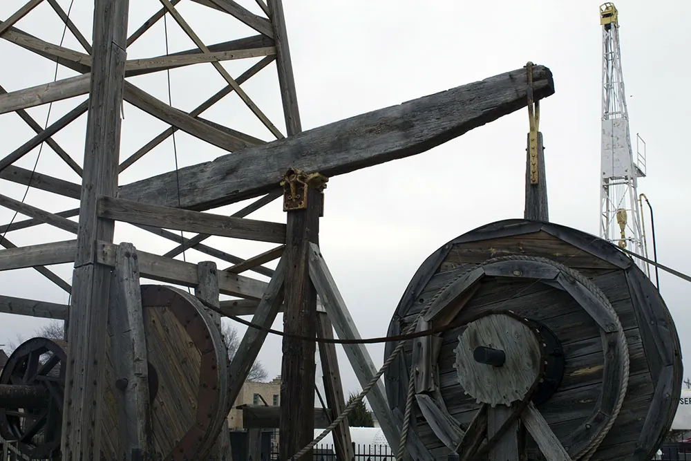 A photo shows an old wooden oil rig.