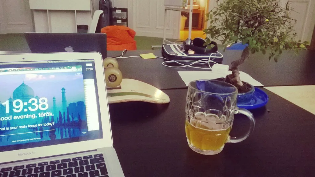 A photograph shows an employees workstation, with a glass half filled with beer.