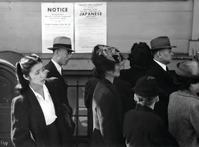 A photograph shows Japanese Americans standing in line in front of a poster detailing internment orders in California.