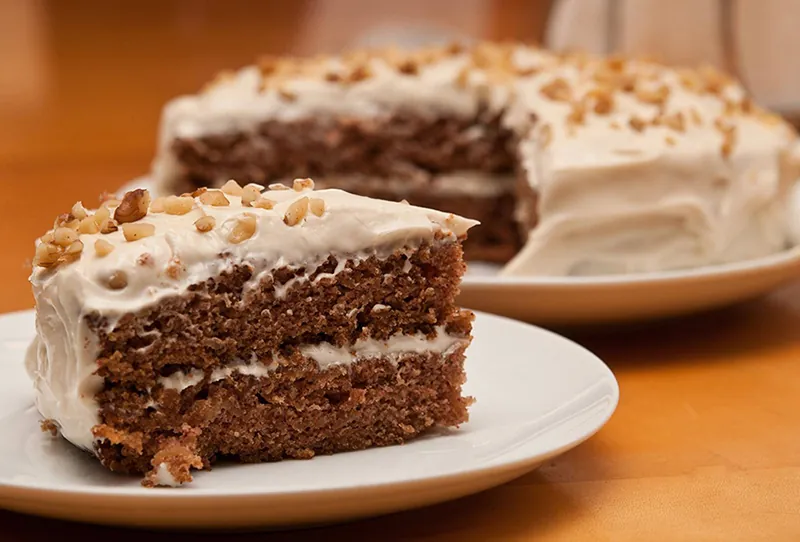 A photo shows a cake with one slice cut out and placed on a plate.