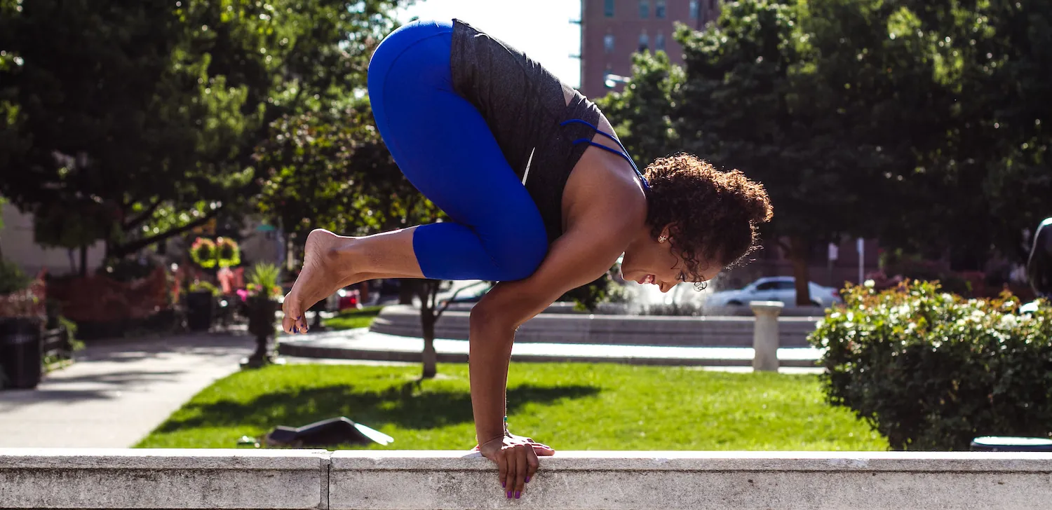 Woman in yoga pose outdoors, smiling