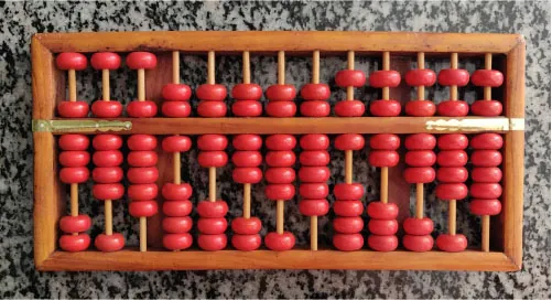 The image depicts a traditional abacus, a simple calculating tool made of a wooden frame and several rods, each holding red beads. The beads can be slid back and forth along the rods to represent numbers for performing arithmetic operations.
