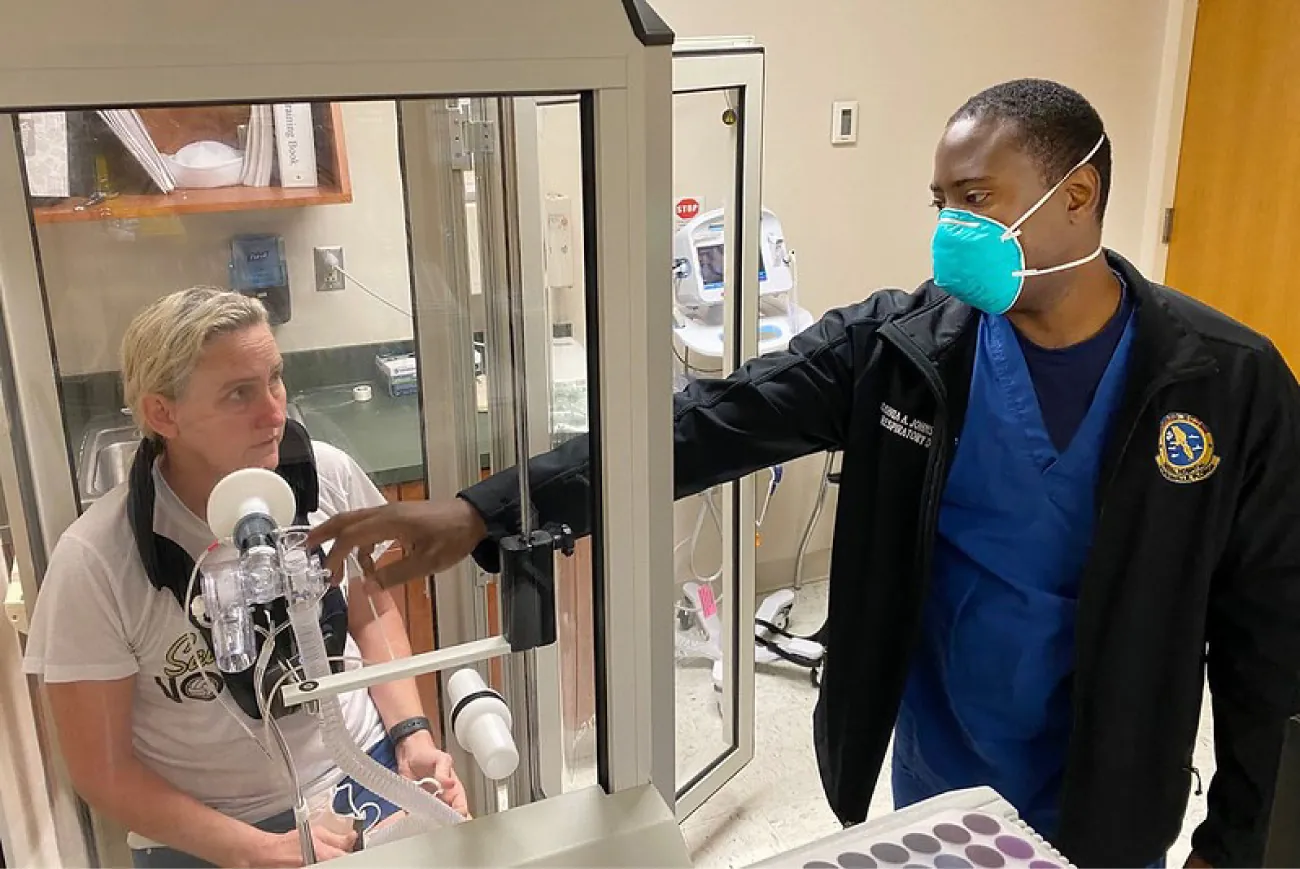 A photo of a nurse setting up a patient for a pulmonary function test.