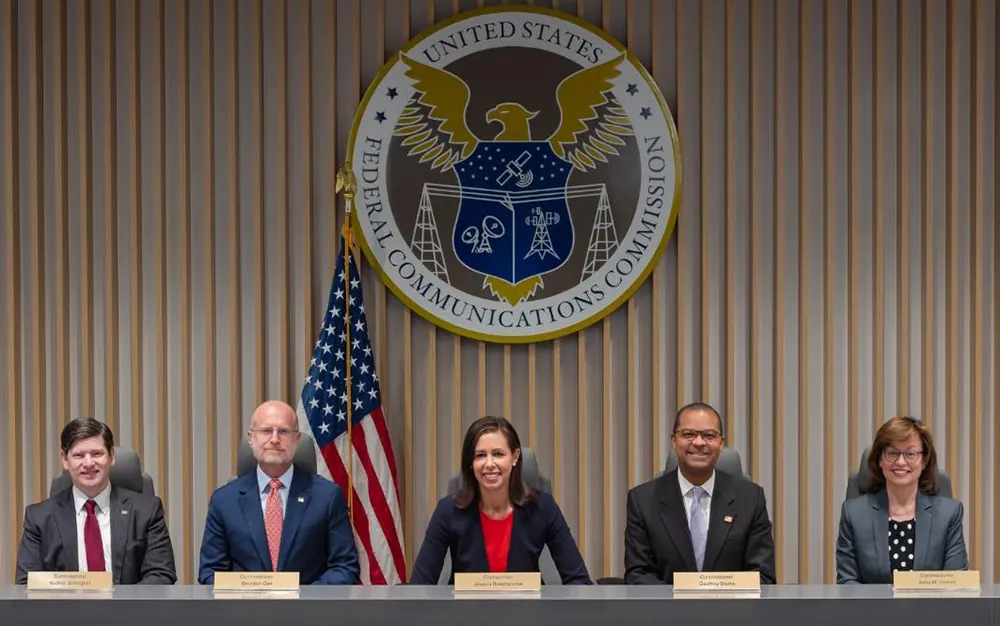 A photograph shows the five commissioners of the F C C, Nathan Simington, Brendan Carr, Jessica Rosenworcel, Geoffrey Starks, and Anna Gomez.