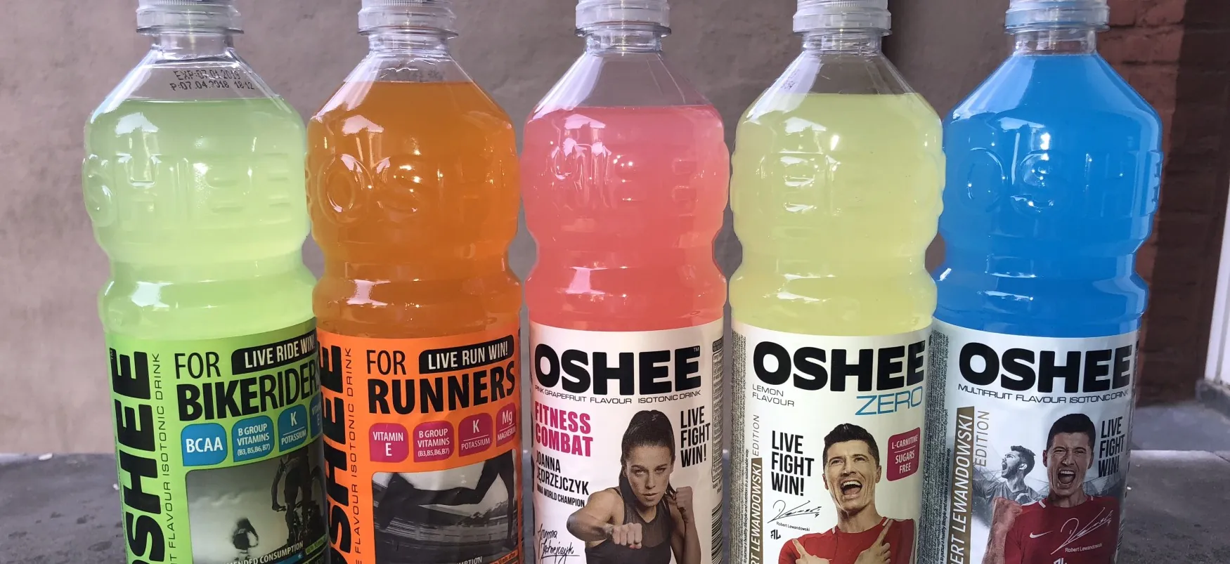 Zdjęcie przedstawia opakowania napojów izotonicznych marki OSHEE