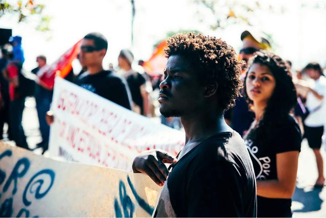 Photo of individuals marching in a rally, holding signs.