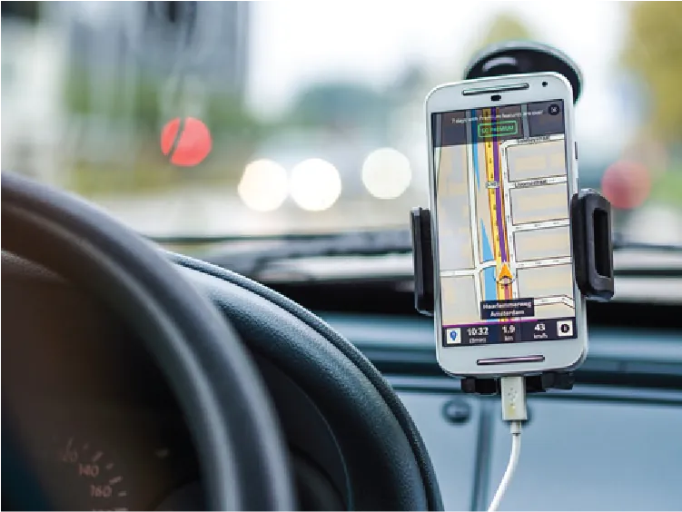 Photo of a smartphone attached to a car’s windshield, displaying a map app.