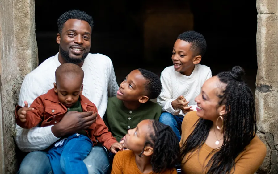 Photo of two adults and four children.