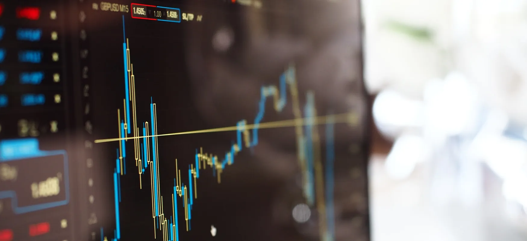 A stock market monitor displays a line graph, showing high and low values over time.
