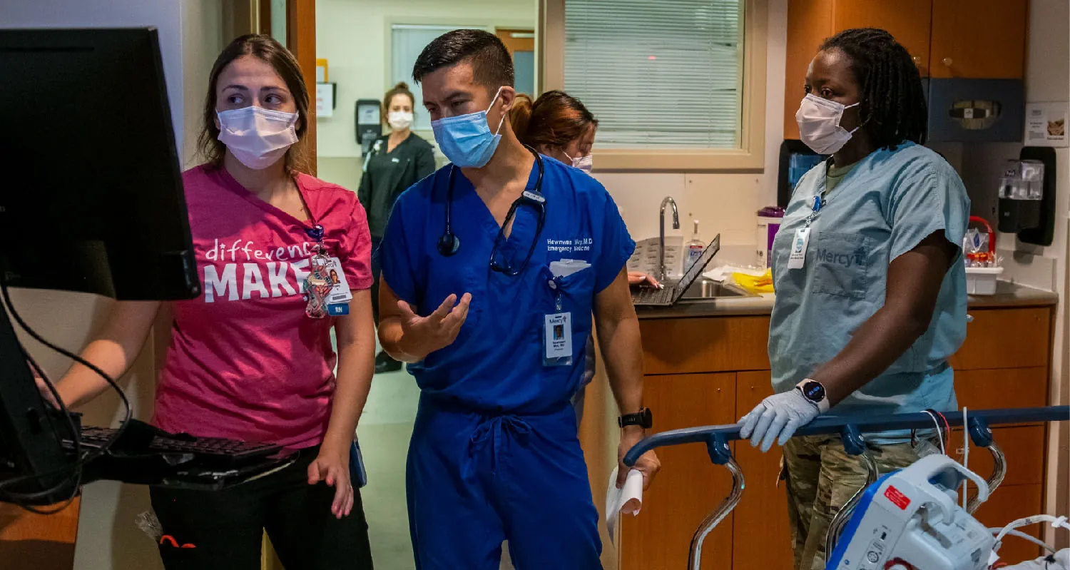Healthcare providers having a discussion while looking at a computer