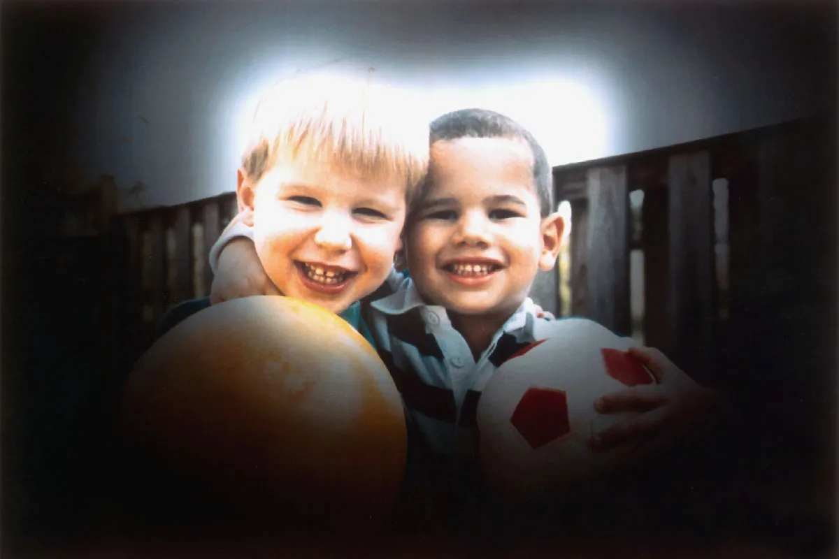 A photo of two kids, with a lighter light in the center and darkened borders around.