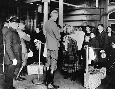 A photograph shows inspectors examining newly arrived immigrants at Ellis Island.