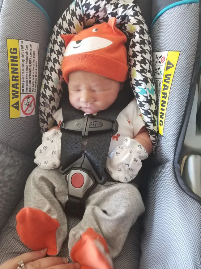 A photograph shows an infant in infant car seat.