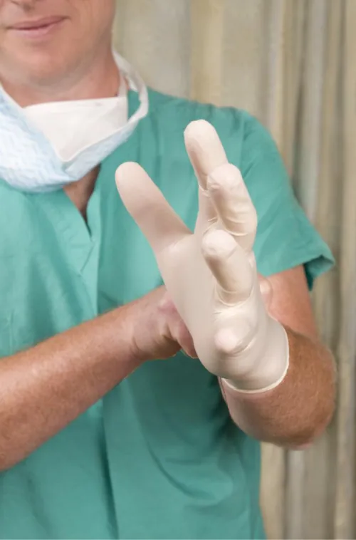 A photograph shows a healthcare worker putting on gloves.