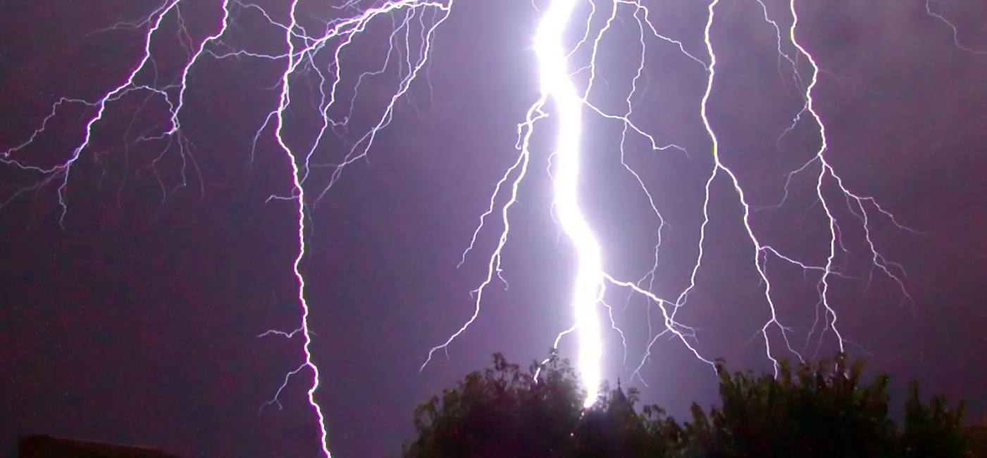 This photo shows branch lightening coming from a dark cloud and hitting the ground.