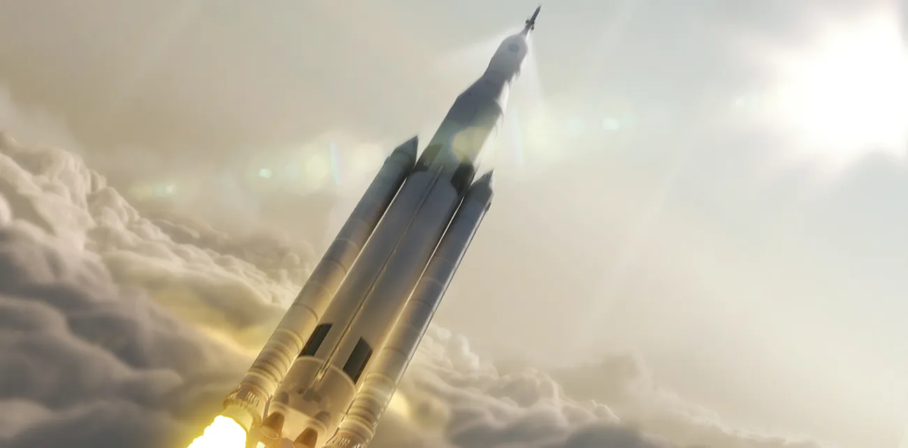 An image is shown of a rocket that appears to have just passed through a layer of clouds as it travels skyward. A bright white light is seen in the upper right corner of the image. To the lower left appears the layer of clouds and the bottom of the rocket with fire projecting from the fuel cones at its base.