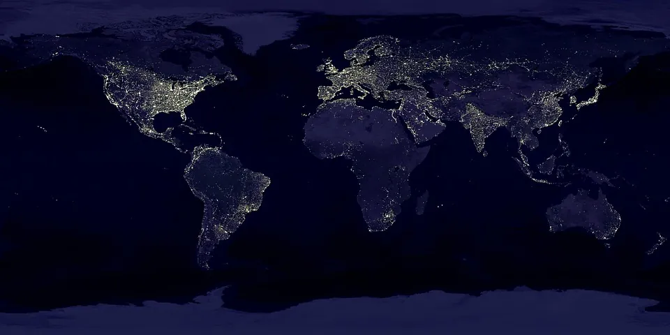 A world map at night showing continents with illuminated areas representing city lights, highlighting population centers in North America, Europe, India, and eastern Asia, while other regions are mostly dark.