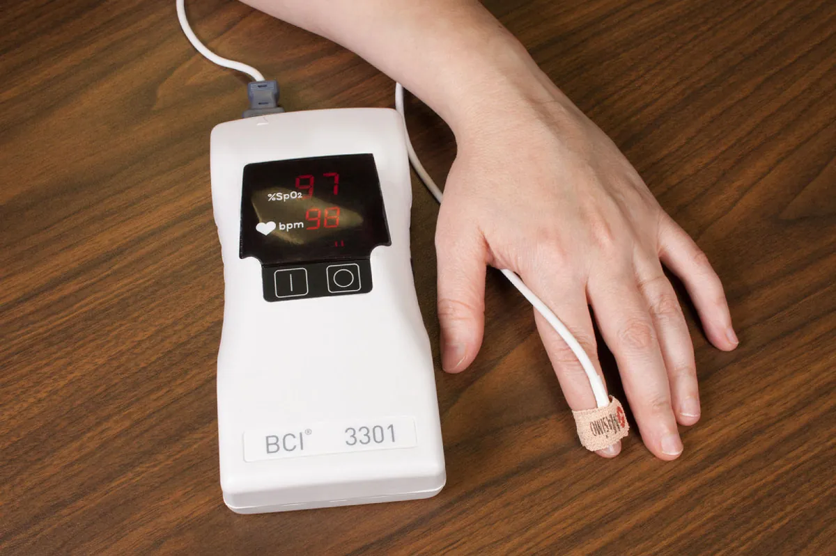 Pulse oximeter attached to patient's finger with tape