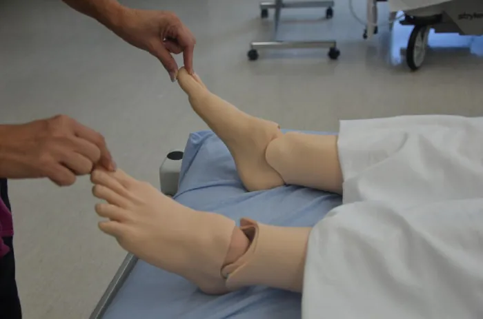 A photo of a nurse assessing capillary refill.