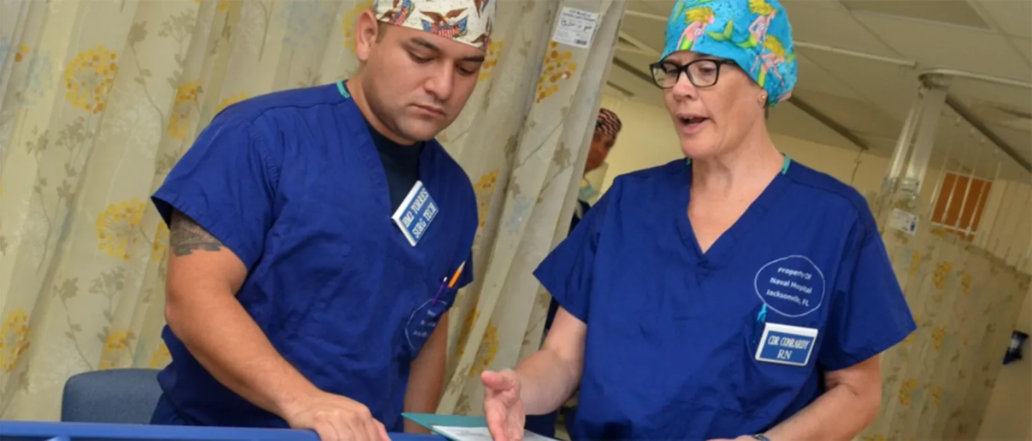 A photograph shows two healthcare workers speaking with each other.