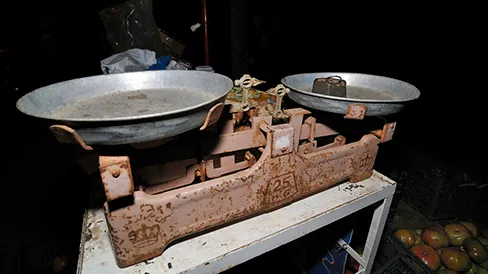 A double-pan mechanical balance is shown. A metal mass is sitting in the left pan.