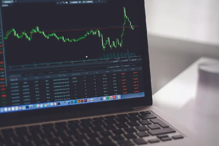 Picture of a laptop with a screen showing a chart of stock prices over time.