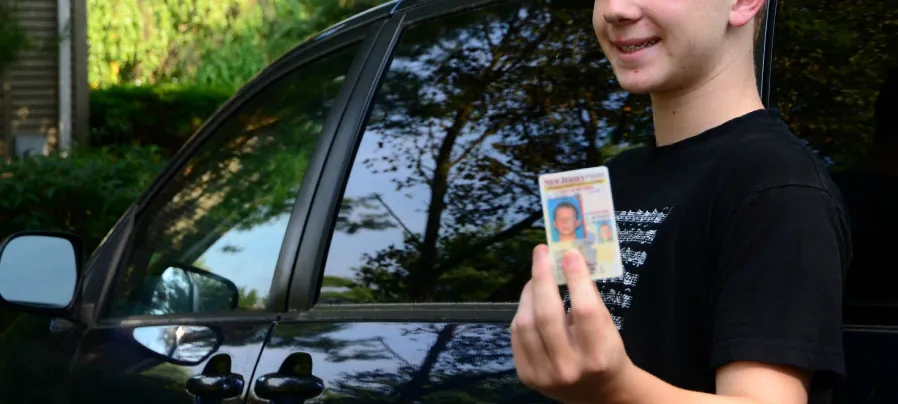 Photo of adolescent holding their driver’s license.
