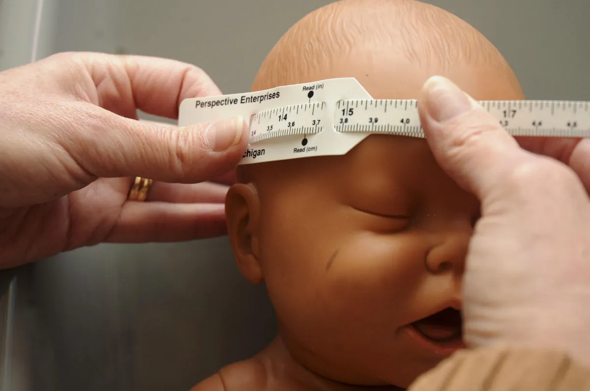 Anthropometric tape being used to measure infant's head circumference