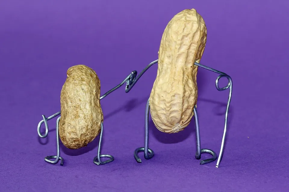 Two peanuts with wire arms and legs stand on a purple background, resembling a parent and child holding hands, with the larger peanut gently holding the smaller ones hand.