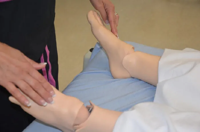 A photo of a nurse assessing dorsalis pedis pulses.
