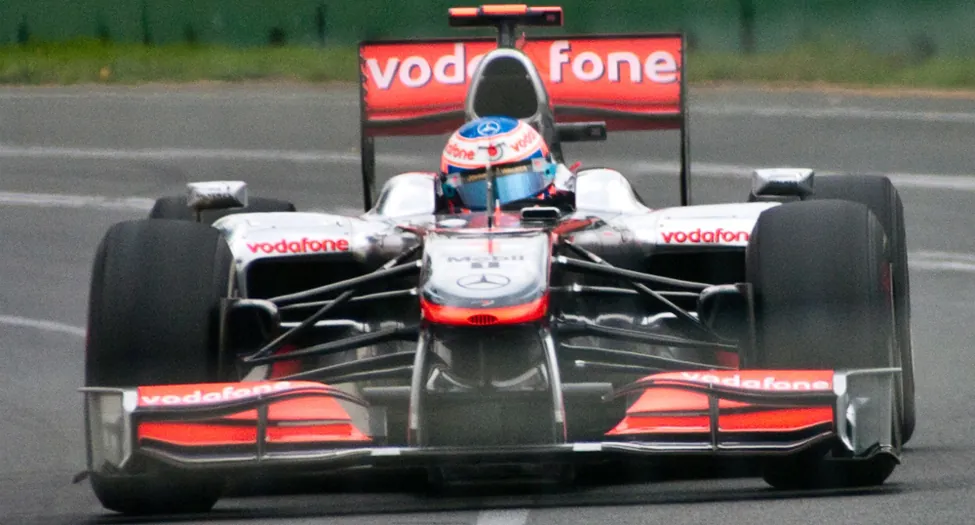 The picture is a race car with large wheels turning on a track.