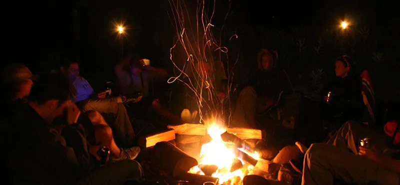 A group of people gathered around a campfire.