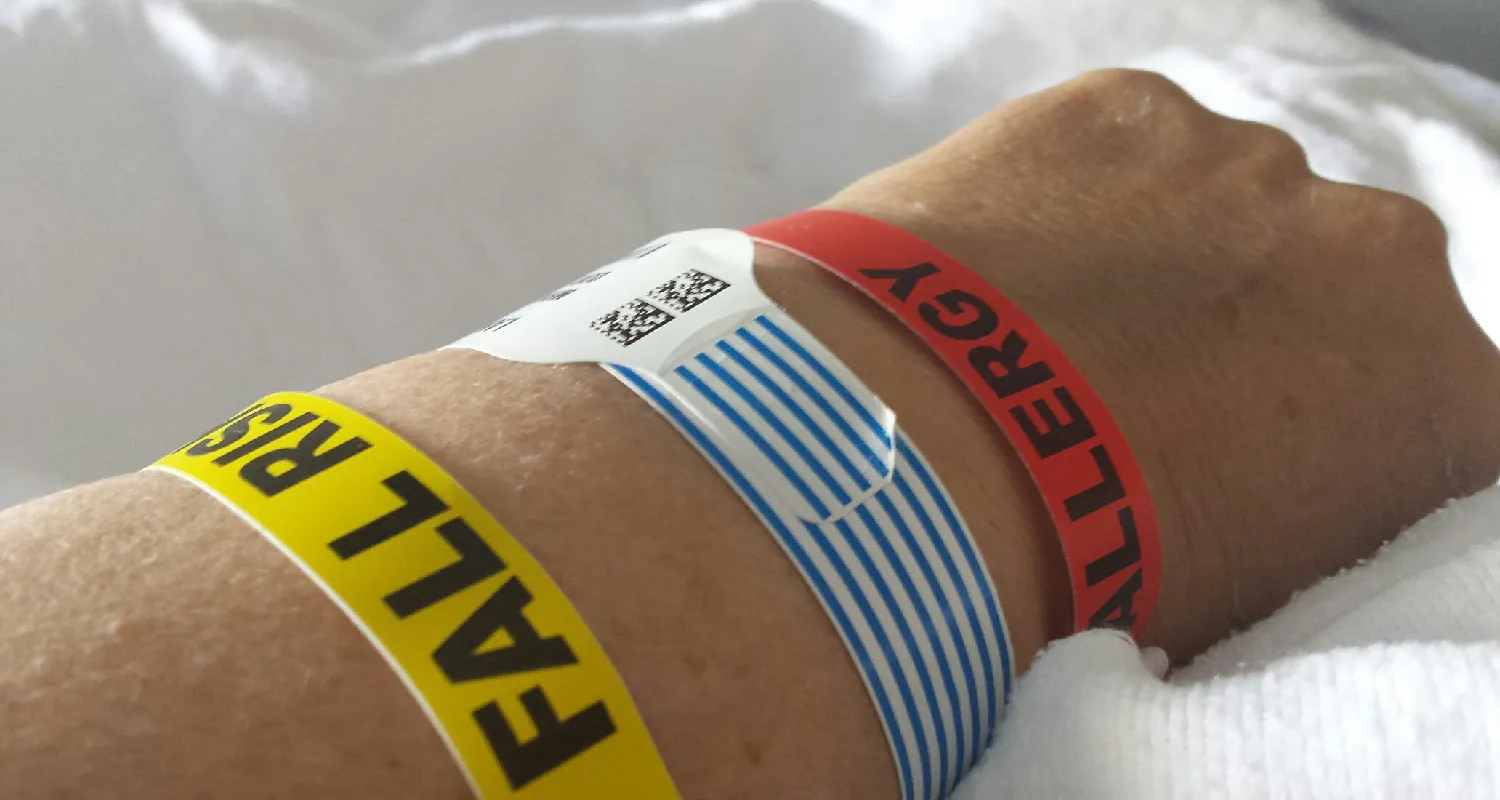 A photograph shows a person holding hands with a patient.