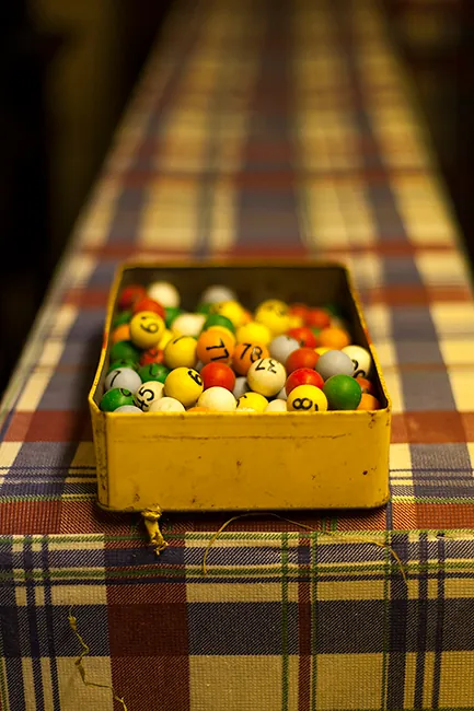 A box of numbered bingo balls is sitting on a table.