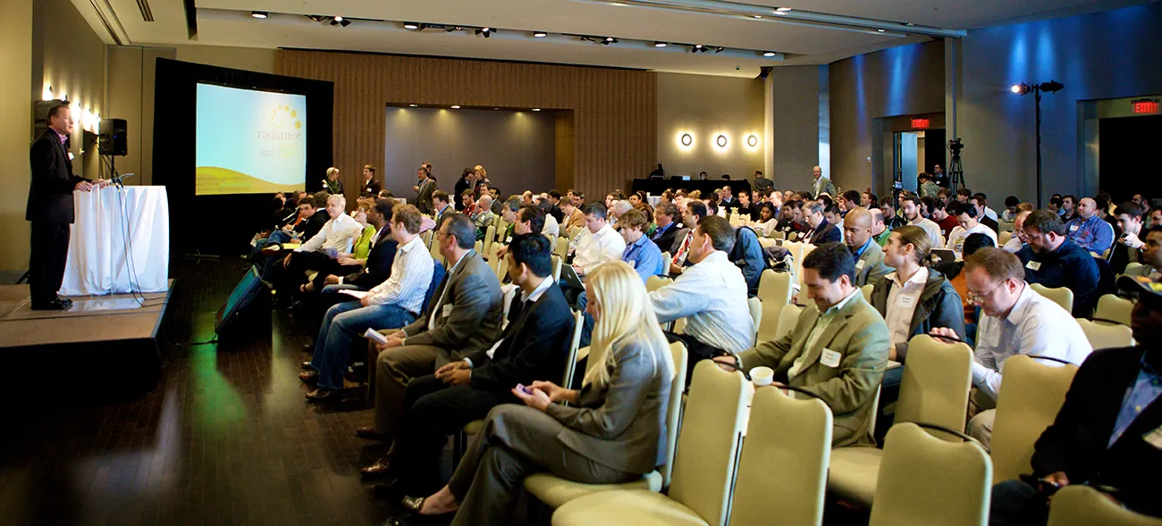 A photo shows a man in a conference hall addressing attendees.